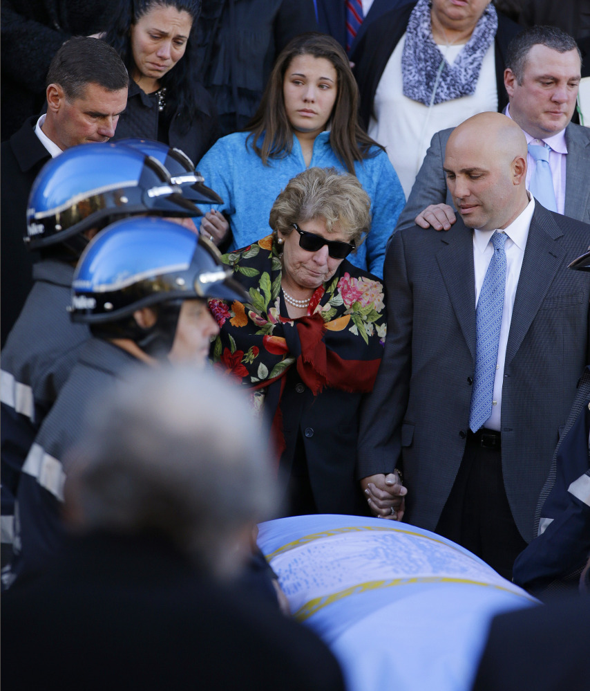 Angela Menino, center, stands behind the casket of her late husband, former Boston mayor Tom Menino, outside a Boston church as the song “My Way” is sung after Menino’s funeral Mass. His successor called him a ‘relentless, big-hearted, people-loving urban mechanic.”