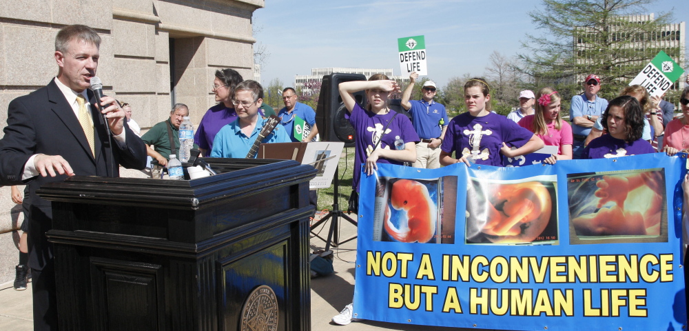 Former Oklahoma state Rep. Kevin Calvey, left, talks Monday to anti-abortion activists at a rally in Oklahoma City, where the issue arouses strong feelings on both sides.