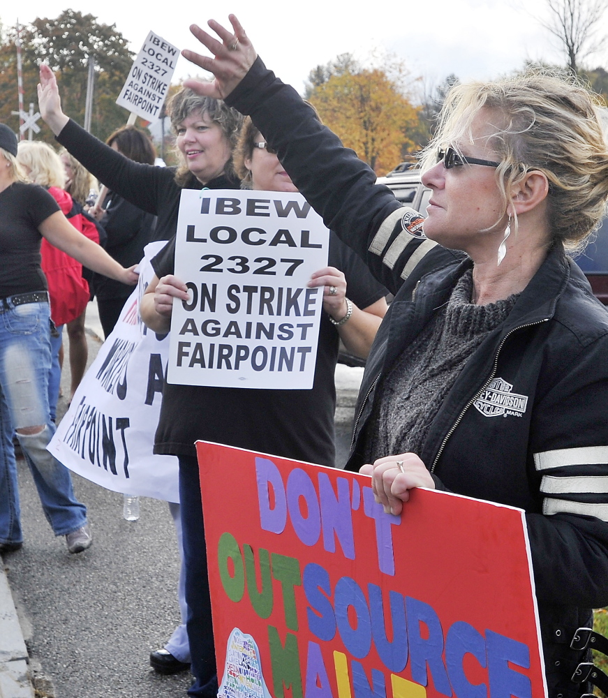 Kandy Sue Sheehan, right, waves at honking cars with FairPoint workers picketing at the corner of Davis Farm Road and Riverside Street in Portland on Oct. 17 after a walkout from FairPoint Communications locations around Northern New England.