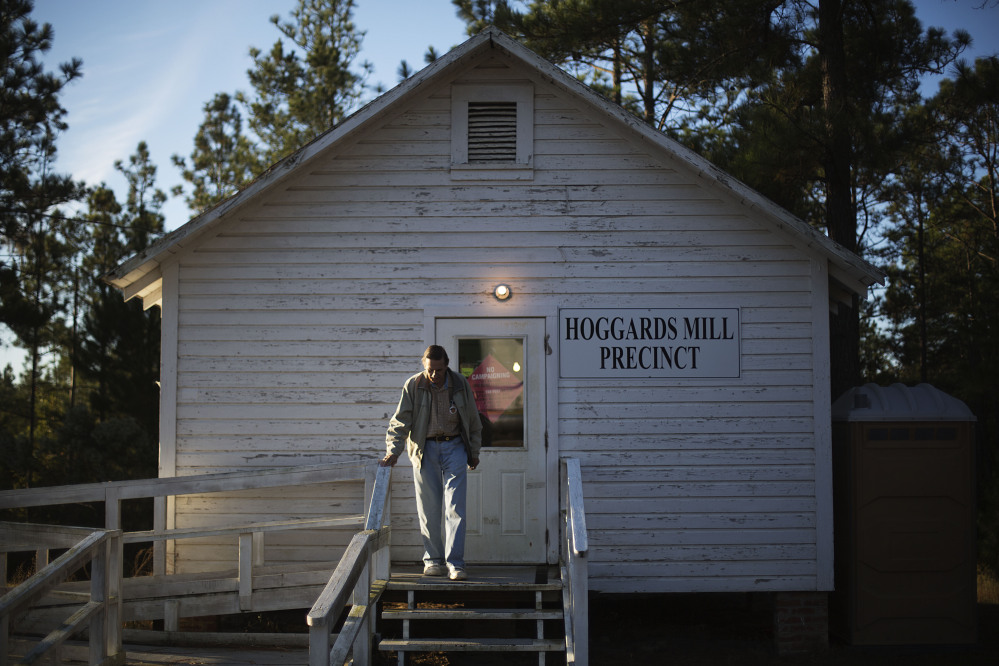 Voter Perry Cross leaves the old Hoggards Mill Courthouse, now a polling site for Baker County, after casting his ballot Tuesday in Newton, Ga.