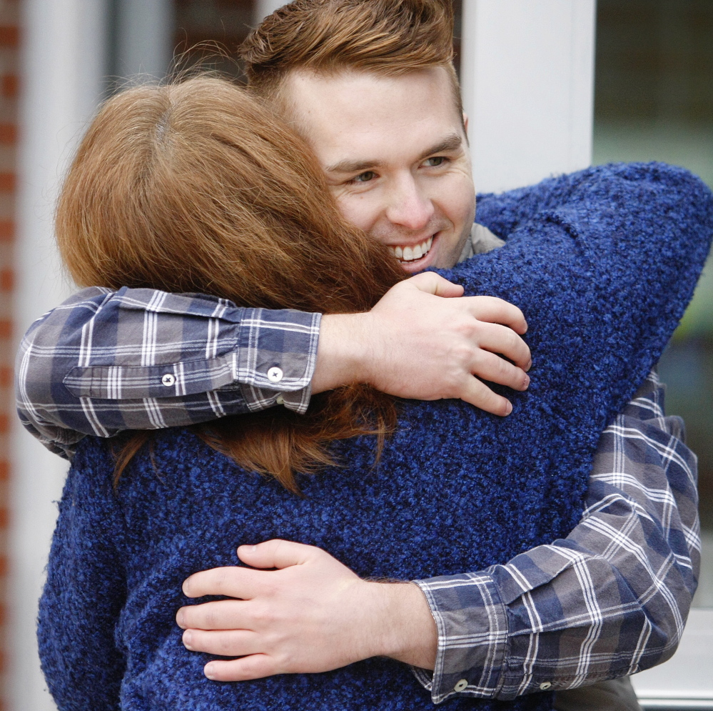 Ryan Fecteau, 22, a Biddeford native, shares a hug with Charlene Dutremble of Biddeford as he greets voters at Biddeford High School on Election Day.