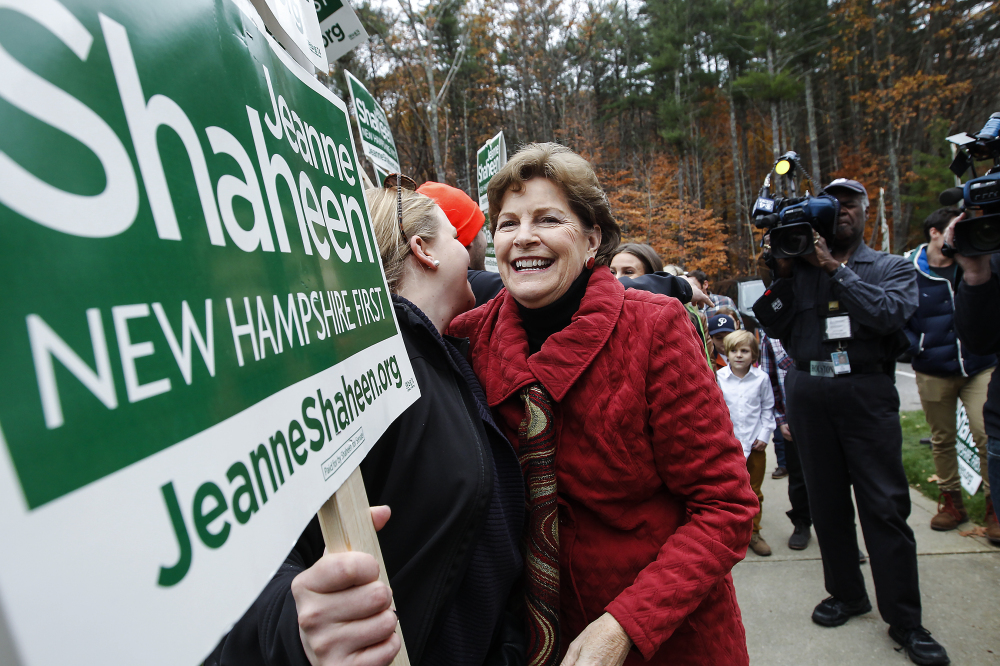 Sen. Jeanne Shaheen, D-N.H., hugs a volunteer holding a sign as she heads in to vote at the Town Hall in Madbury, NH,  Tuesday, Nov. 4, 2014.  Shaheen, a Democrat seeking a second term, faces Republican Scott Brown, who is seeking to represent a second state. Brown moved to New Hampshire last year after losing his U.S. Senate seat in Massachusetts.  (AP Photo/Cheryl Senter)