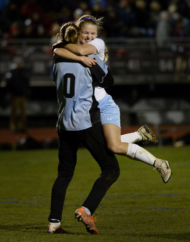 Jordan Sargent jumps into the arms of goalie Elizabeth Mycock after Windham defeated Scarborough 2-1 in the Western Class A girls’ soccer title on Wednesday.