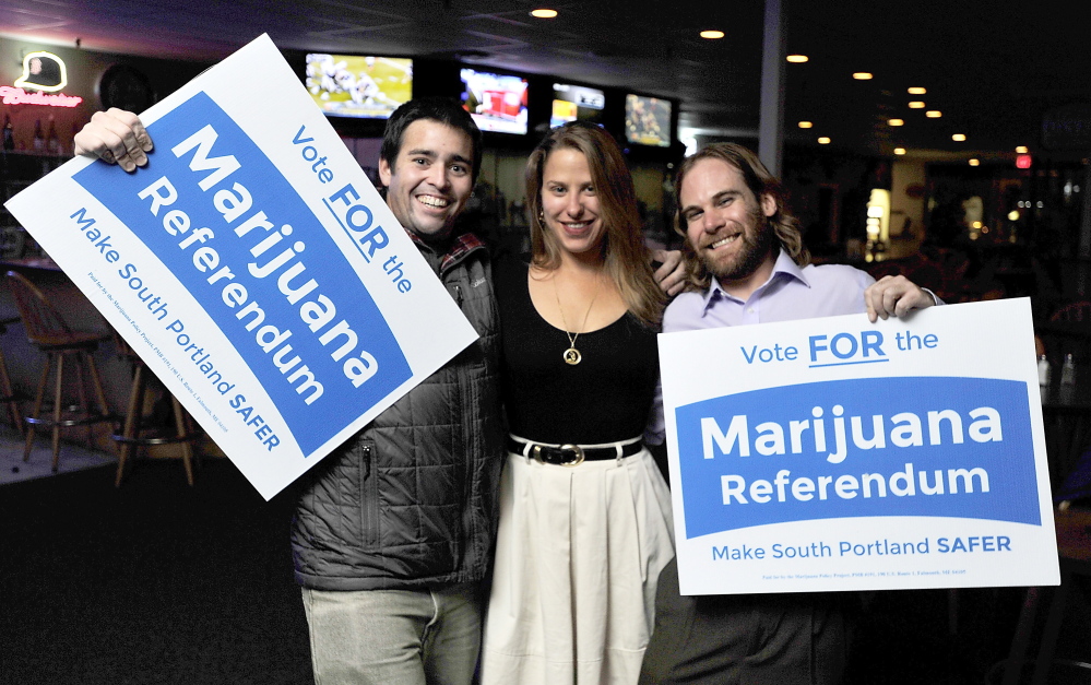 Matthew Bourgeois, Erin Daly and Chris Blake, volunteers for the passage of the marijuana referendum, show their joy with the passing in South Portland, at Thatchers in South Portland. 