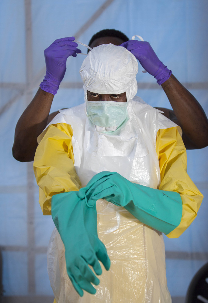 A health care worker in Sierra Leone is tested on protection equipment procedure.