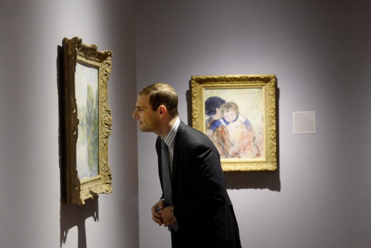 Andrew Eschelbacher, assistant curator of European art, studies Claude Monet’s “The Seine at Vetheuil” at the Portland Museum of Art.