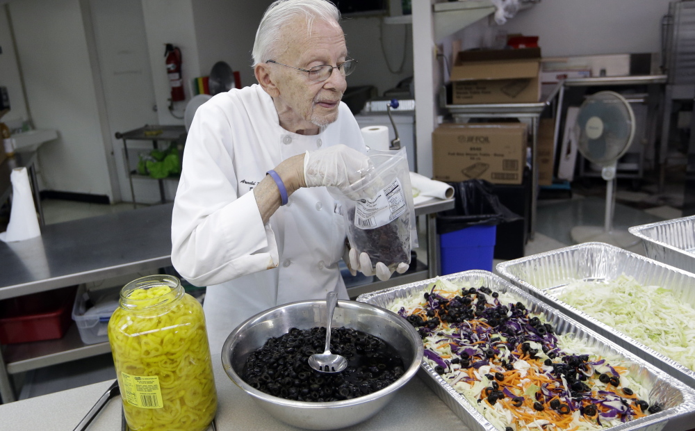 Homeless advocate Arnold Abbott, 90, director of the nonprofit group Love Thy Neighbor Inc., prepares a salad in the kitchen of The Sanctuary Church on Wednesday in Fort Lauderdale, Fla.
The Associated Press