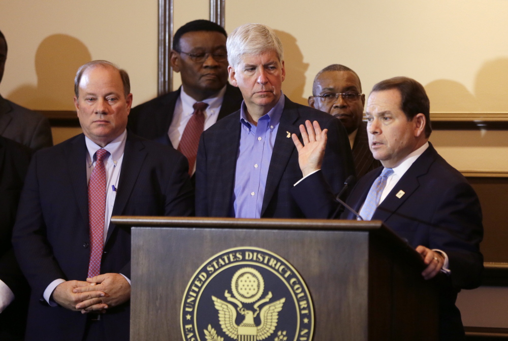 Judge Gerald Rosen, right, gestures toward Michigan Gov. Rick Snyder during a news conference Friday. “What happened in Detroit must never happen again,” Rosen said.