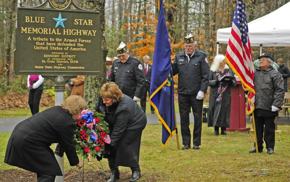 Debra Burnham, of the Garden Club Federation of Maine, left, and first lady Ann LePage assist in the dedication of the new Blue Star Memorial Highway marker on Friday in Augusta.