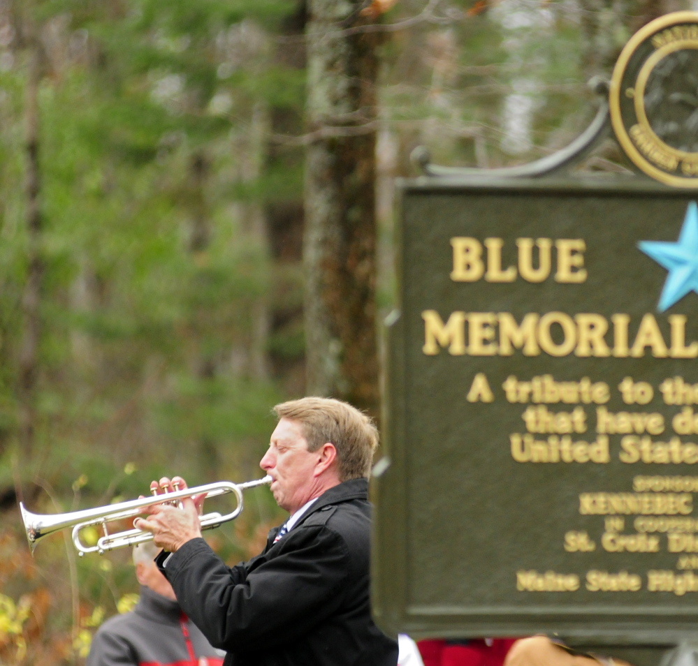 Dwight Tibbetts plays taps at the end of the dedication ceremony in Augusta.