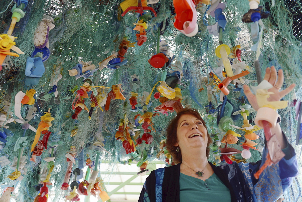 Angela Haseltine Pozzi stands under her work “Ocean Gyre,” which is part of the “Washed Ashore” educational exhibit at Mystic Aquarium in Mystic, Conn, through June.