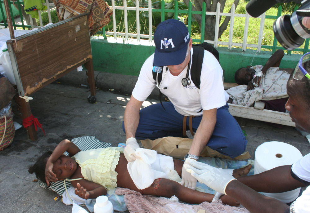 Dr. Robert Fuller provides medical care to an earthquake survivor in Port-au-Prince, Haiti, in 2010. Three weeks of quarantine imposed on medical professionals who volunteer to go to West Africa to help care for Ebola patients adds to the complications of volunteering, and it isn’t likely that Fuller will be able to participate.