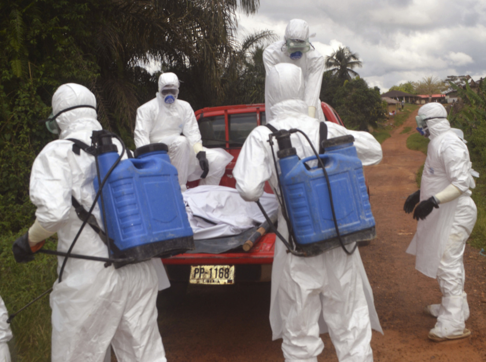 Health care workers load the body of a dead woman suspected of dying from Ebola, onto a truck in Jenewonde near the Liberia-Sierra Leone border, where medical care is now largely dependent on volunteers with Doctors Without Borders.