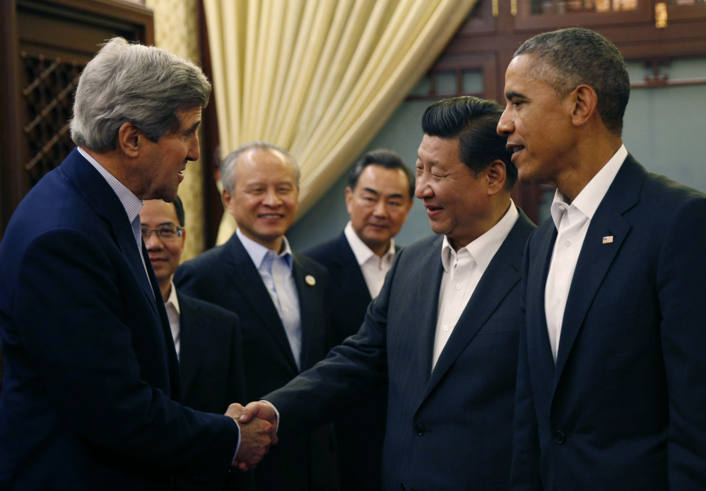 President Obama looks on as China’s President Xi Jinping shakes hands with U.S. Secretary of State John Kerry during a two-day Asia Pacific Economic Cooperation summit in Huairou, China.