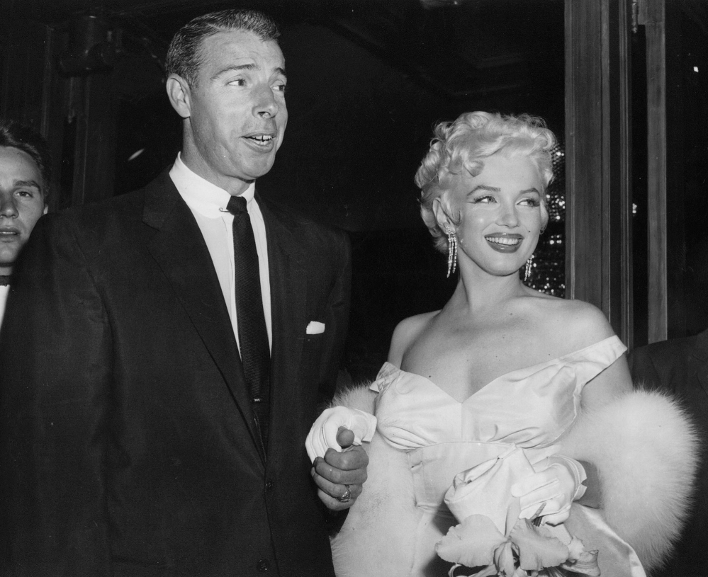 In this June 2, 1955 file photo, actress Marilyn Monroe, right, dressed in a glamorous evening gown, arrives with Joe DiMaggio at the theater.