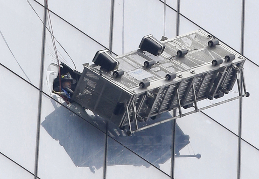 A firefighter looks out an opening cut into a window at 1 World Trade Center after rescuing two workers from their collapsed scaffolding Wednesday. The two window washers were trapped for more than an hour on the south side of the 1,776-foot, 104-story building.