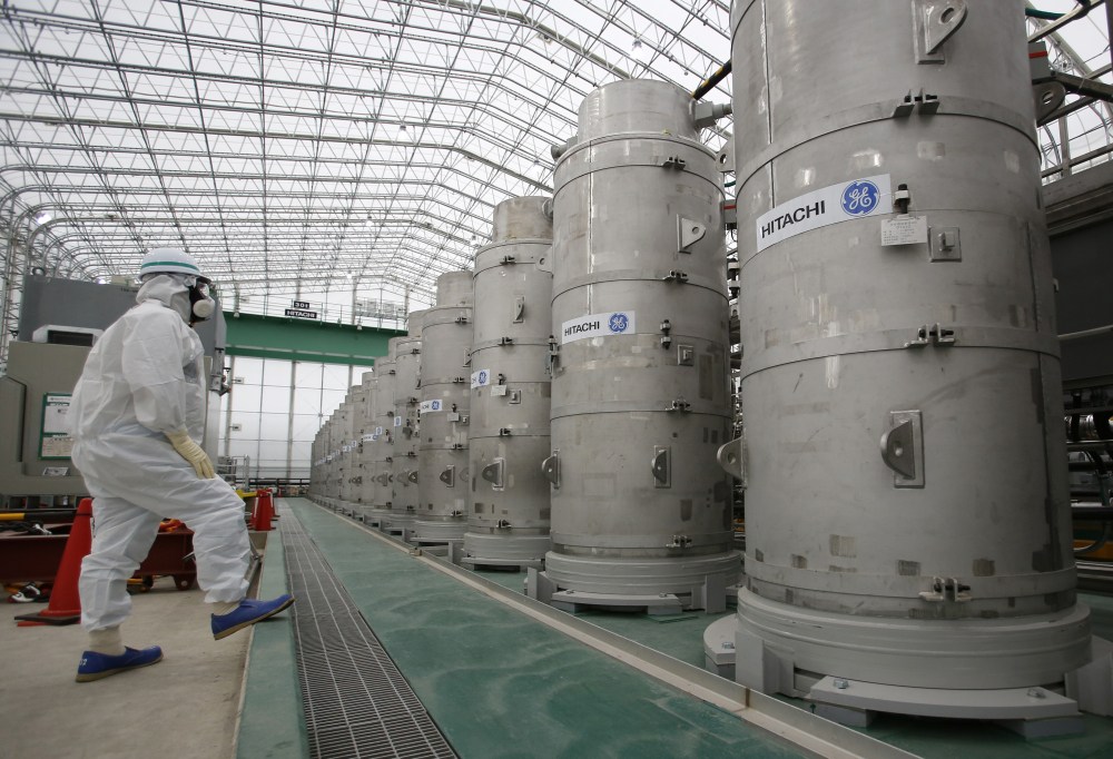 A visitor wearing protective gear looks at a system designed to remove radioactive elements from water at the Fukushima Dai-ichi nuclear power plant in northeastern Japan.