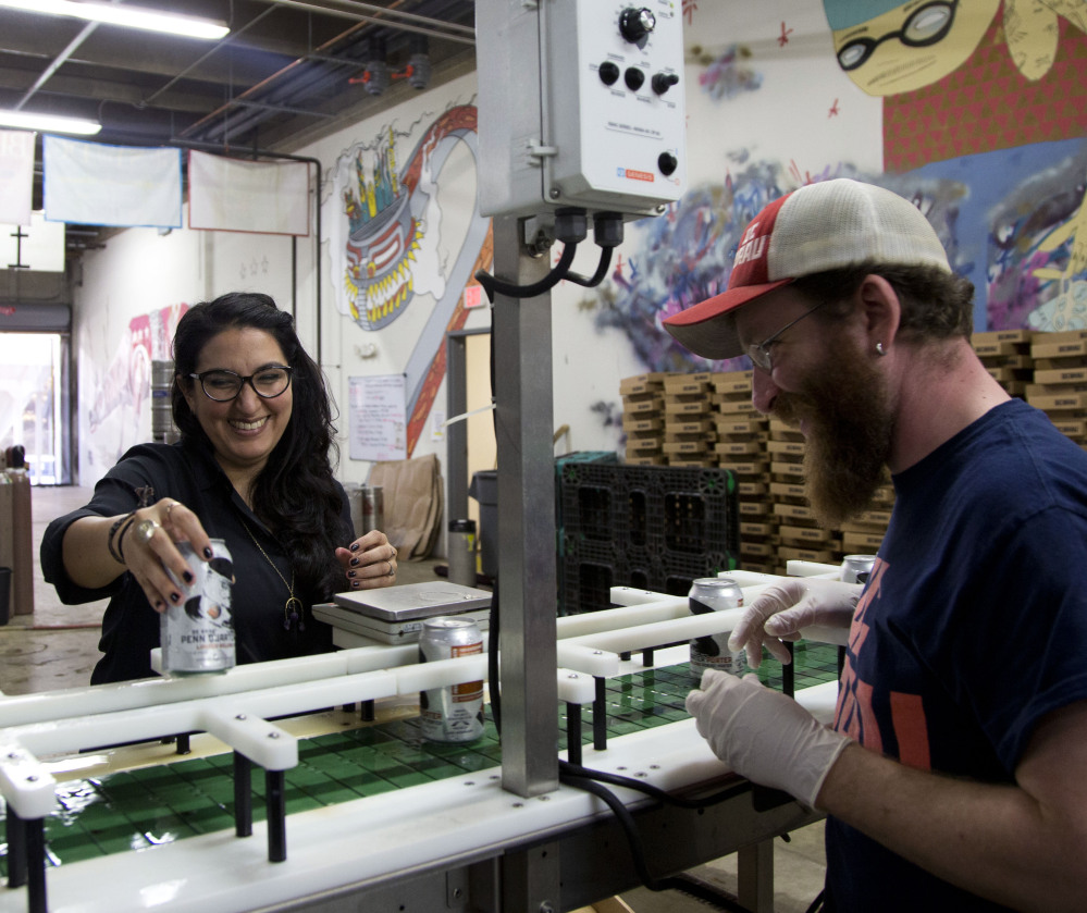Employee Jason Budman works with Mari Rodela, chief community and culture officer for DC Brau Brewing Co. in Washington. The microbrewery lined up more than 50 insurance options for its workers through the small-business exchange.