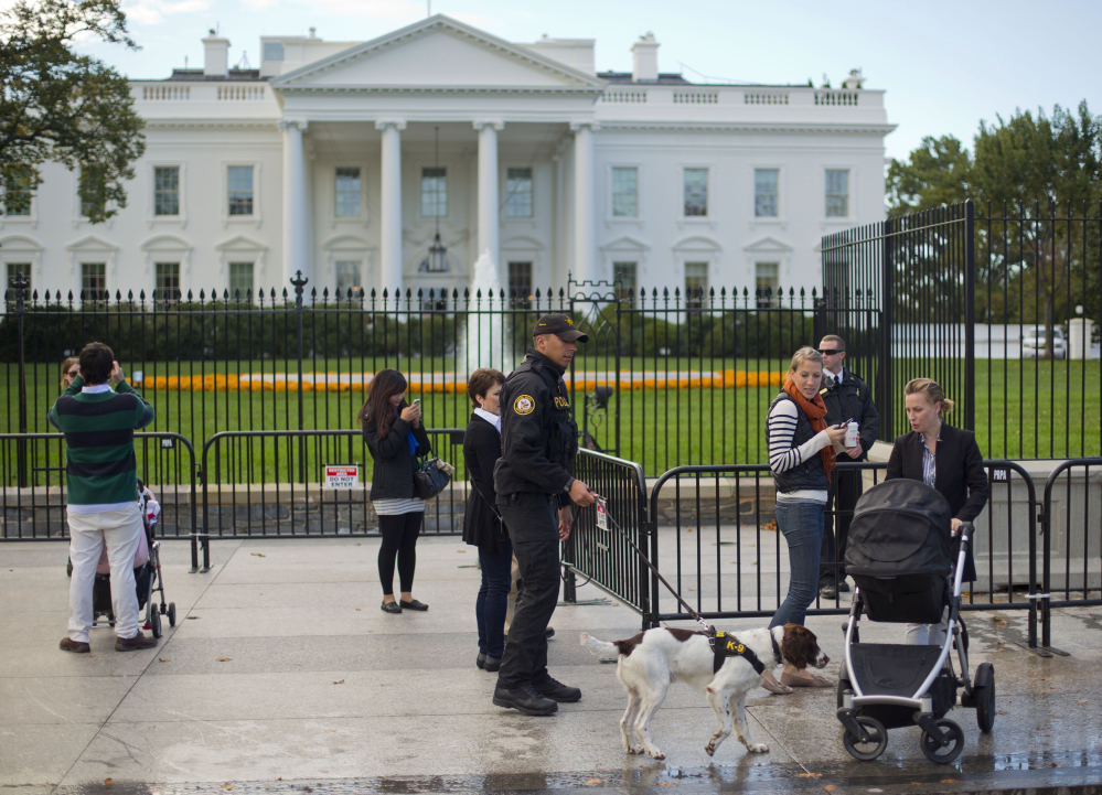 A Secret Service police officer dog patrol walks on the sidewalk in front of the White House in Washington last month.