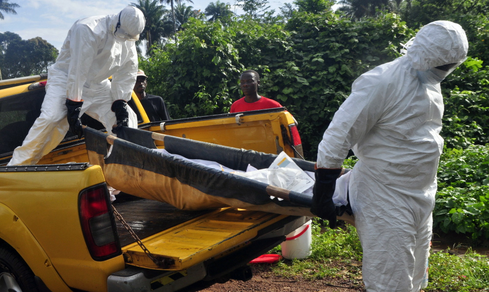 Health workers unload the body of a man suspected of contracting the Ebola virus near Monrovia, Liberia, last month. Comparing patients receiving drug therapy to patients who are not is a long-established testing technique considered the gold standard of medical research.
