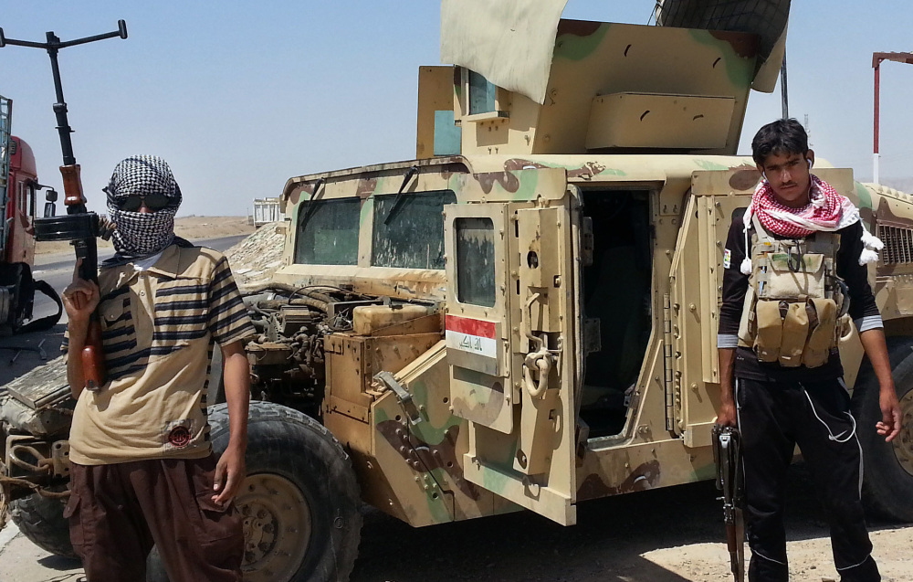 Militants stand with a captured Iraqi army Humvee last spring near an oil refinery in Beiji. The recapture of Beiji is the latest in a series of setbacks for the Islamic State.