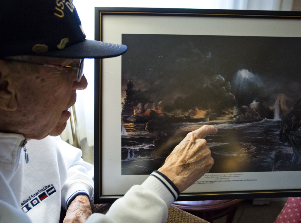 Lendall Knight, 95, points out the Japanese battleship Hiei in a painting of the Naval Battle of Guadalcanal that hangs on his wall at an assisted living facility in Cumberland. Knight was a lieutenant in the Navy aboard the USS O’Bannon, which is credited with helping to sink the Hiei 72 years ago.