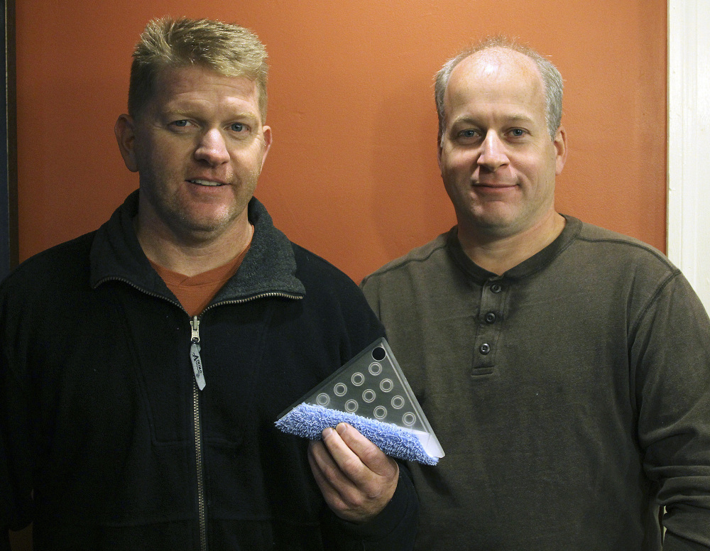 Lynn, Mass., firefighters Rusty Jordan, left, and Marcel Thivierge, display their invention, a Simple Tool, a three-in-one triangular kitchen cleaning tool that Jordan invented and then developed along with Thivierge. 