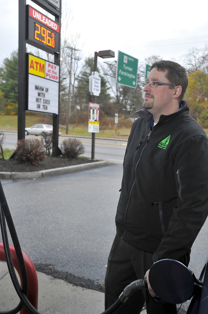Limerick resident Josh Bisson fills his tank with gas in Auburn, where he works, for $2.96 a gallon. As oil prices plummet, he has gone from spending $65 twice a week to top off his Subaru to $55 for each fill-up, saving $20 a week.