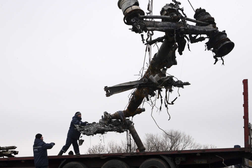 Recovery workers in rebel-controlled eastern Ukraine load debris from the crash site of Malaysia Airlines Flight 17, in Hrabove, Ukraine, Sunday, four months after the plane was brought down.