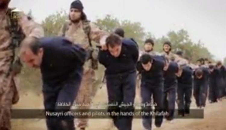 This still image taken from an undated video published on the Internet by the Islamic State group and made available Sunday purports to show extremists marching Syrian soldiers before beheading them.