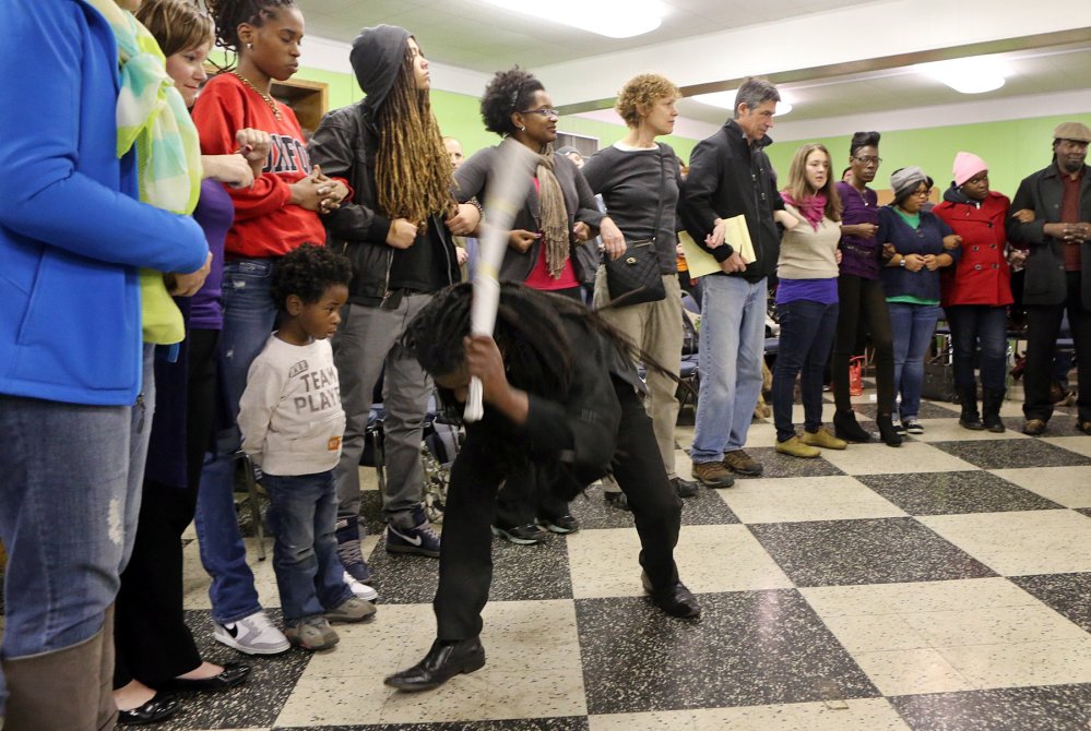 The Rev. Osagyefo Sekou, a pastor from the First Baptist Church in Jamaica Plain, Mass., demonstrates, at a protest training session in St. Louis, Mo., last week, how police might try to intimidate protesters by beating on the ground with their clubs. 