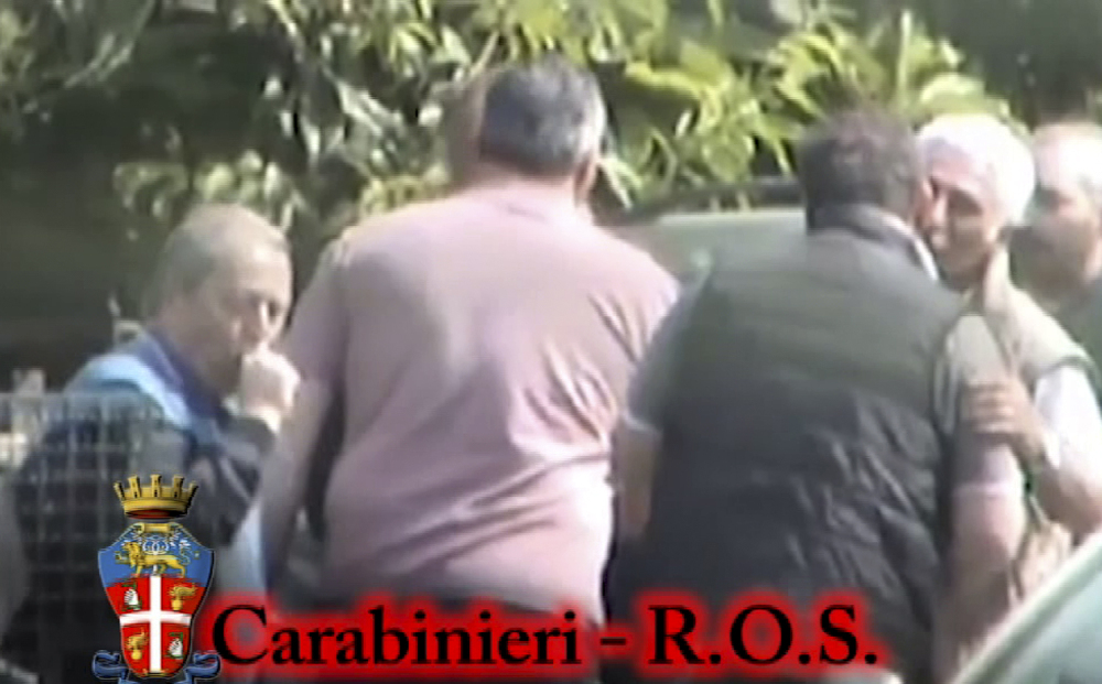 In this photo taken from a video provided by the Italian Carabinieri, or paramilitary police, people identified by police as Italian crime sindicate ‘ndrangheta’ members greet each other.