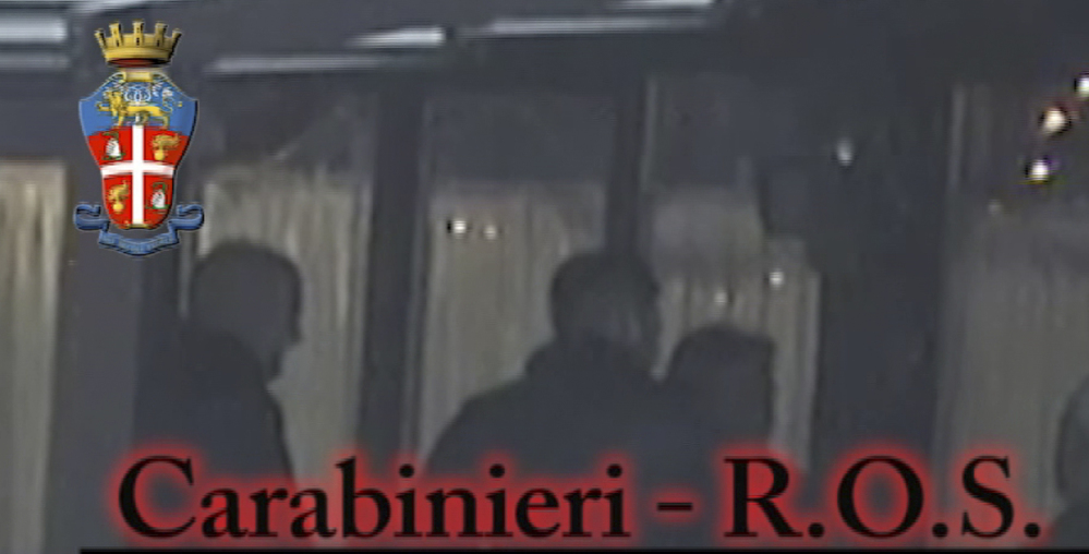 In this photo taken from a video provided by the Italian Carabinieri, or paramilitary police, people identified by police as Italian crime sindicate ‘ndrangheta’ members perform a ritual swearing-in ceremony.