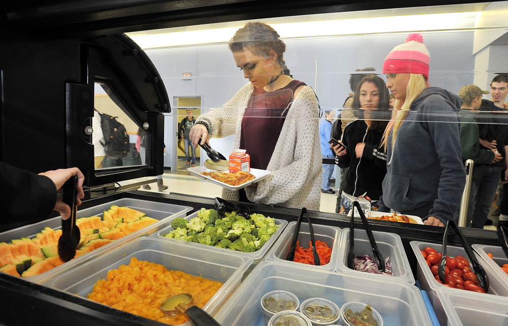 Abby Davis, a junior, adds fruit to her lunch as students at Kennebunk High School are given the opportunity to select vegetarian entrées and fruits and vegetables.