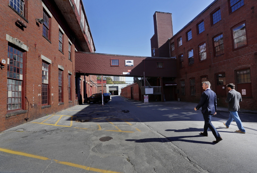 James Brady, left, and Casey Prentice, owners of the former Portland Co. complex, walk around the site in October. A zoning request to the Portland Planning Board asks for the waterfront site to be classified as mixed-use. All that the developers have  promised so far is that none of the proposed buildings will rise higher than 35 feet above Fore Street. Derek Davis/Staff Photographer
