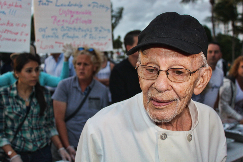 Arnold Abbott, left, is a 90-year-old World War II veteran who heads the Love Thy Neighbor organization in Fort Lauderdale, Fla. His group of volunteers helps to feed homeless people in the city by hosting meals, top photo, outside in a local park. A new ordinance was passed to restrict outdoor feedings – a move the city’s mayor hoped would persuade Abbott to find an indoor venue for his charitable services.