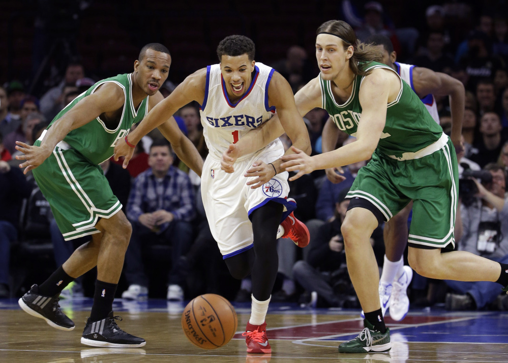 The Philadelphia 76ers’ Michael Carter-Williams, center, chases after a loose ball between Boston Celtics Avery Bradley, left, and Kelly Olynyk during the first half of Wednesday night’s game in Philadelphia. Boston improved to 4-6 with the win.