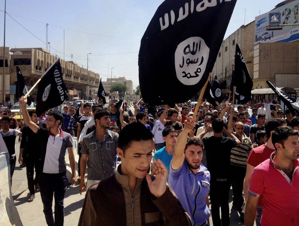 Demonstrators chant pro-Islamic State slogans as they carry the group’s flags at a rally in Mosul, Iraq.