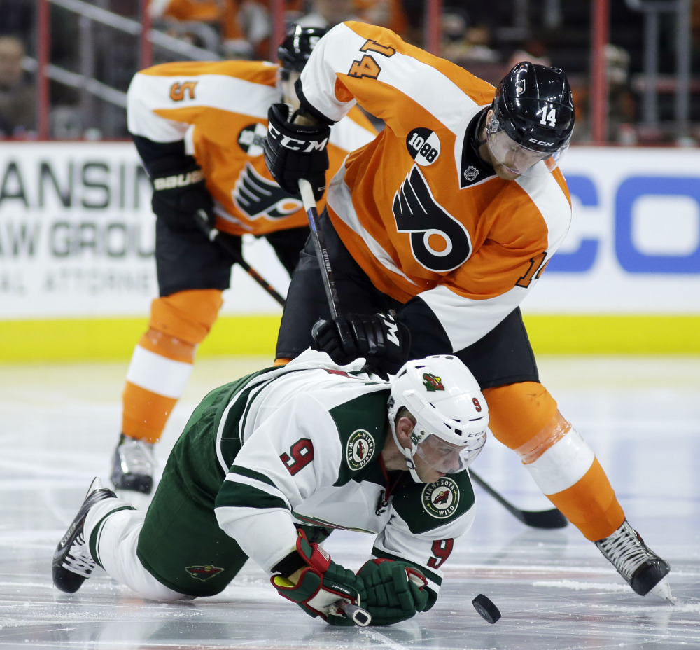Without a stick, the Wild’s Mikko Koivu battles for the puck with the Flyers’ Sean Couturier during the second period of Thursday night’s game in Philadelphia. Minnesota won 3-2 on Jason Zucker’s goal in the final minute.