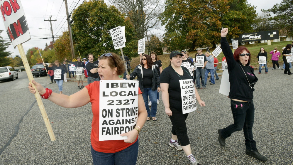 Renee Dugas, left, walks a picket line with other striking FairPoint employees in Portland last month. The walkout at FairPoint is now more than a month old.