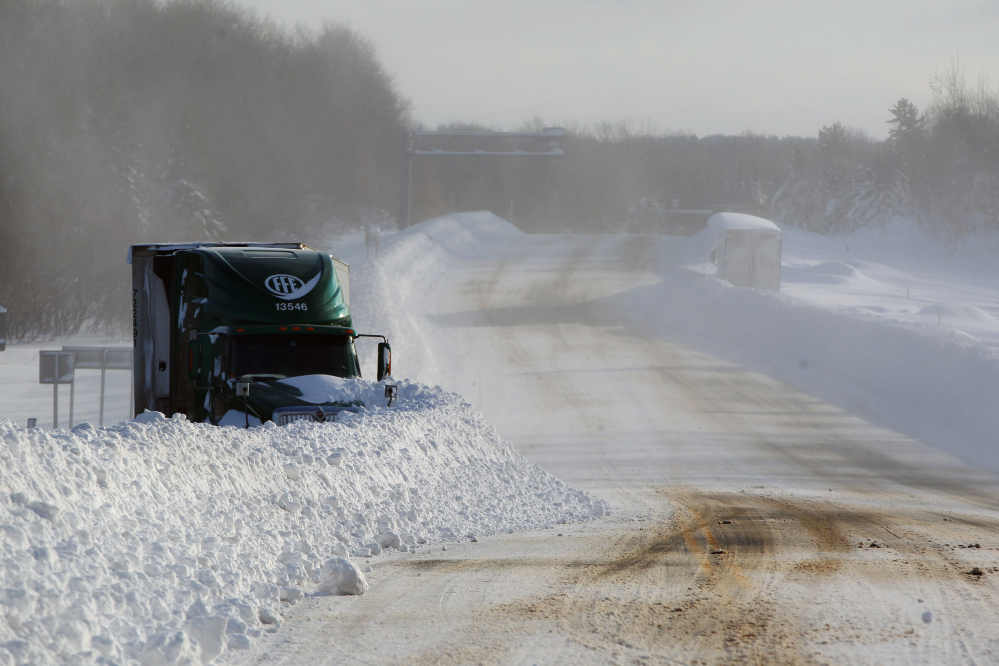 Snow covers a stranded truck in Orchard Park, N.Y.