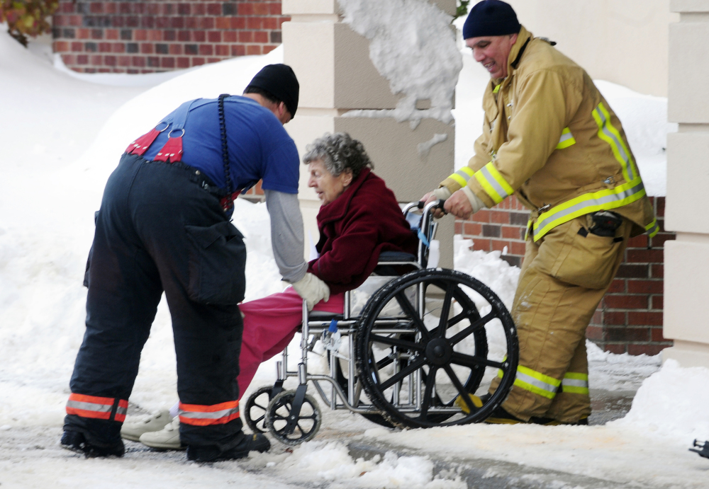 Firefighters assist an elderly patient from the Garden Gate Health Care Facility  in Cheektowaga, N.Y.