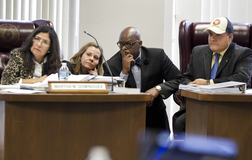 State Board of Education members, from left, Martha M. Dominguez, Donna Bahorich, Lawrence A. Allen Jr. and Ruben Cortez Jr. look toward other members during a recess on hearings Friday to approve textbooks in Austin, Texas.