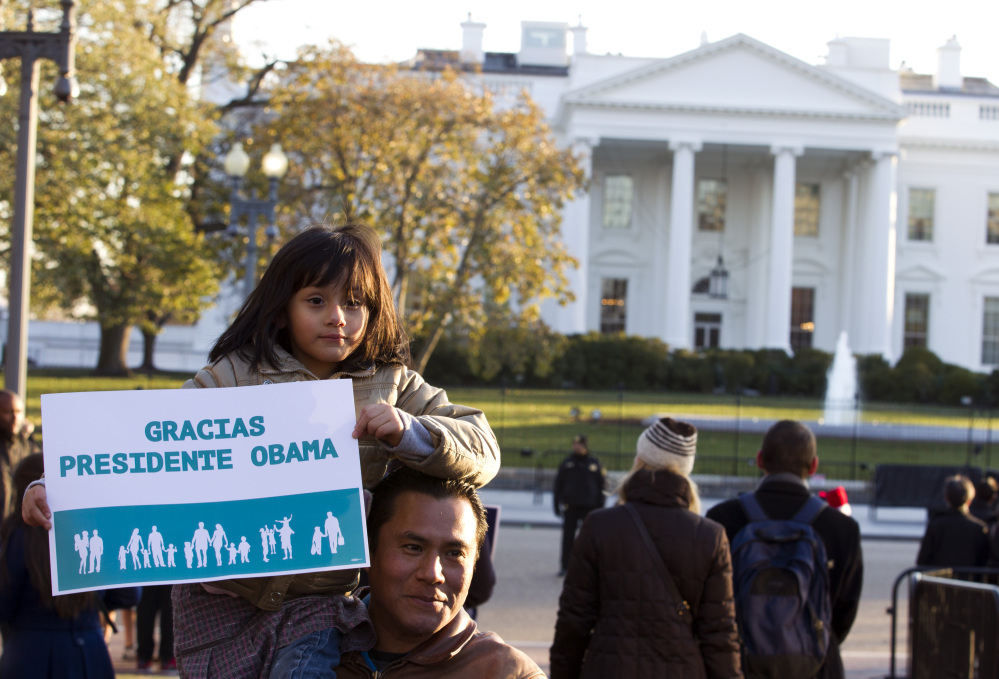 Israel Montalvo holds up his daughter Brianna for a photo while attending a pro-immigration rally in front of the White House on Friday, Nov. 21, 2014.
The Associated Press