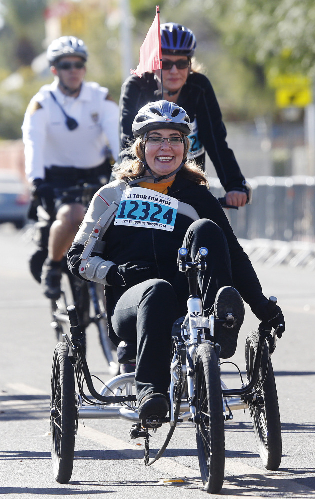 Former U.S. Rep. Gabrielle Giffords arrives back at the finish line for the 12-mile fun ride at the Special Olympics El Tour de Tucson bicycle race on Saturday in Tucson, Ariz..