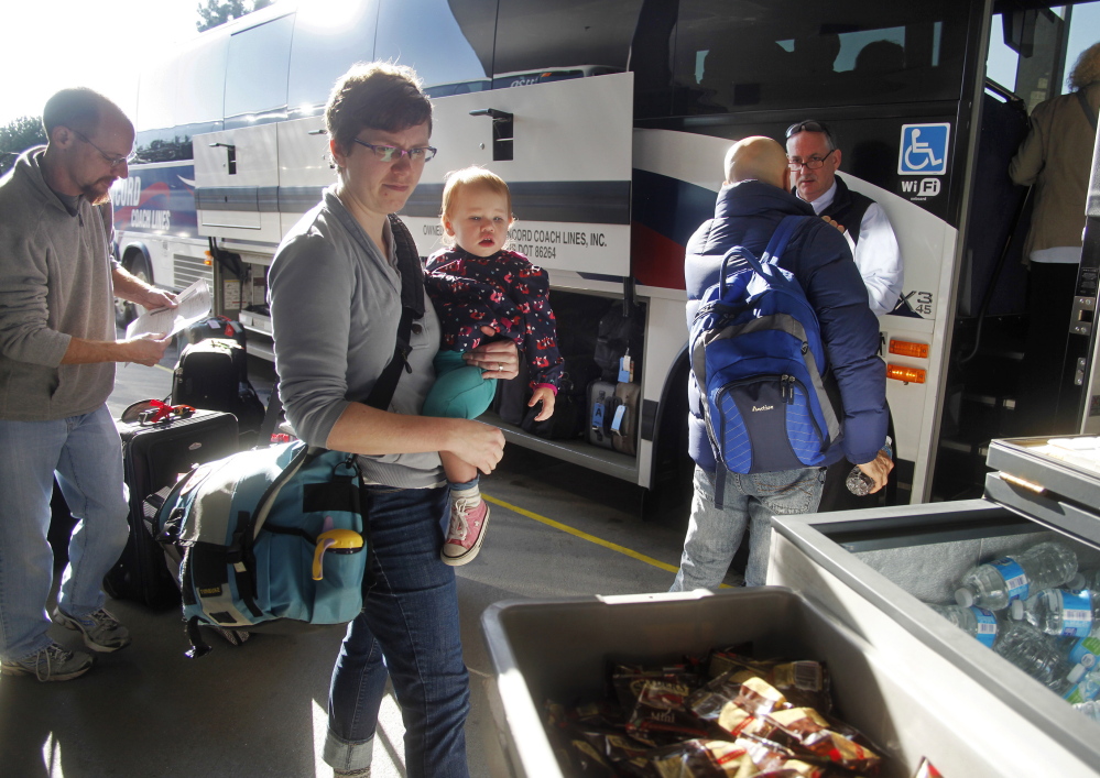 Leah Thibeault of Westbrook her daughter, Autumn, 18 months, and her husband, John, left, are among the throng of holiday travelers this week. The Thibeaults are traveling from Maine to southern California for Thanksgiving.