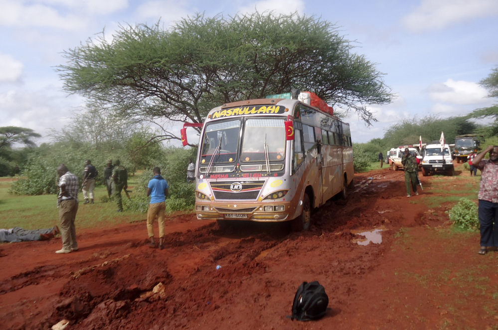 Kenyan security forces and others gather around the scene of an attack on a bus near the Somali border Saturday. Somalia’s Islamic extremist rebels, al-Shabab, attacked the bus in Kenya at dawn Saturday, killing 28 passengers.