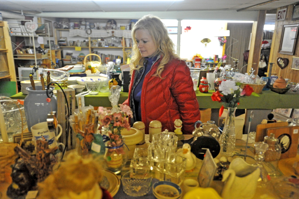 Susan Roy, executive director of Hospice Volunteers of Waterville Area, organizes donated merchandise in the resale shop.