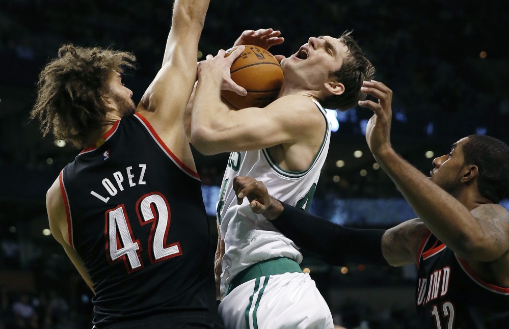 Portland’s Robin Lopez fouls the Celtics’ Tyler Zeller during the second period of Sunday’s game in Boston, won by the Trail Blazers – the seventh straight victory for the NBA’s Northwest Division leaders.
