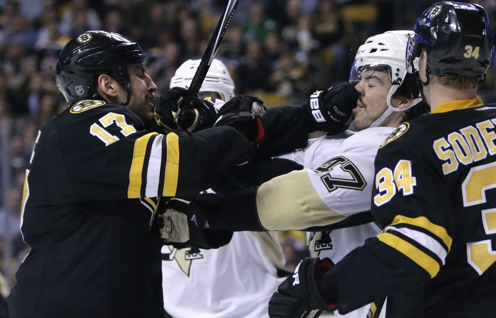 Boston Bruins left wing Milan Lucic jabs Pittsburgh Penguins defenseman Simon Despres in the face during the second period of Monday night’s game in Boston.
